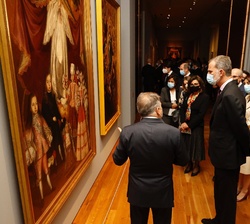 Su Majestad el Rey acompañado de las personalidades asistentes a la inauguración de la exposición en un momento de su recorrido